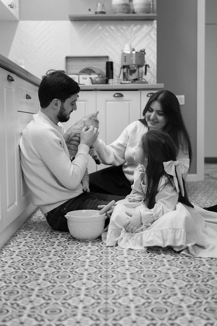 Service Happy family bonding with a kitten in their stylish kitchen, radiating warmth and love.